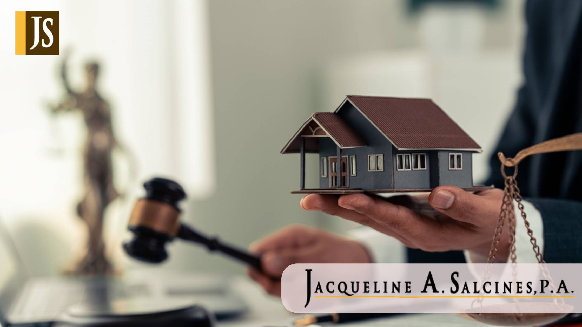 Auctioneer points at house model and holds hammer during auction Hammer sitting on block in front of real estate auction house
