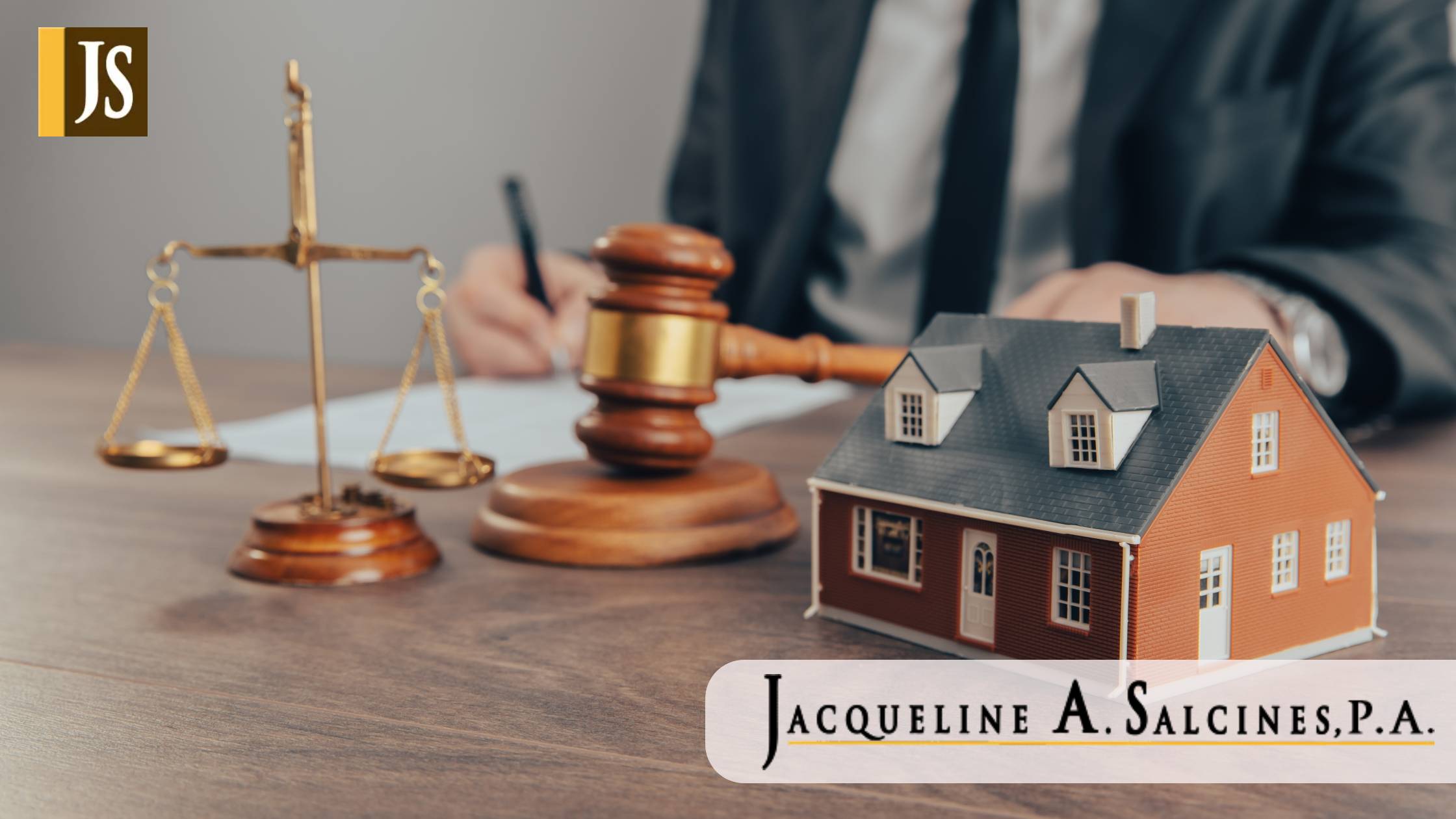 The hand of a judge with a gavel and a model of a house mediating property disputes in court